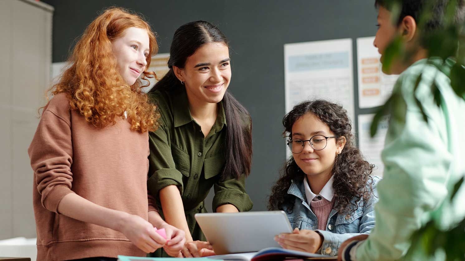 Vier Schülerinnen zusammen an einem Tablet.